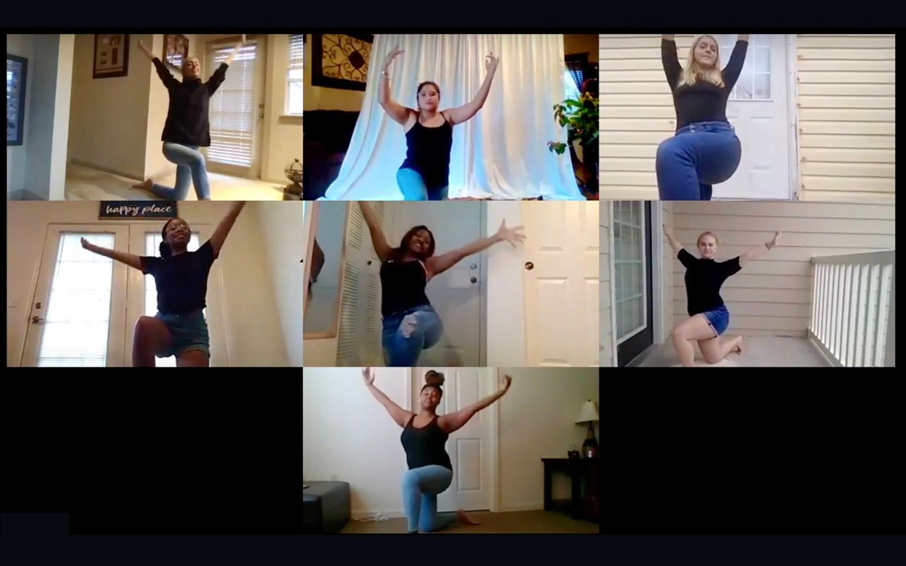 Borderless Arts digital dancers a screenshot of a Zoom or webinar session with 7 young women of varying ages and races doing a similar dance pose with their arms lifted in the air above their head while kneeling on one knee. They are all dressed alike in black shirts and jeans. They are doing a dance lesson together virtually