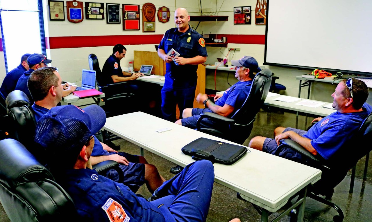 Breaking Ground 93 - Chatt SNAP program a meeting room with a standing firefighter training seven seated firefighters. The trainer is Captain Phillips, and he is describing the SNAP training, which is described in the article.