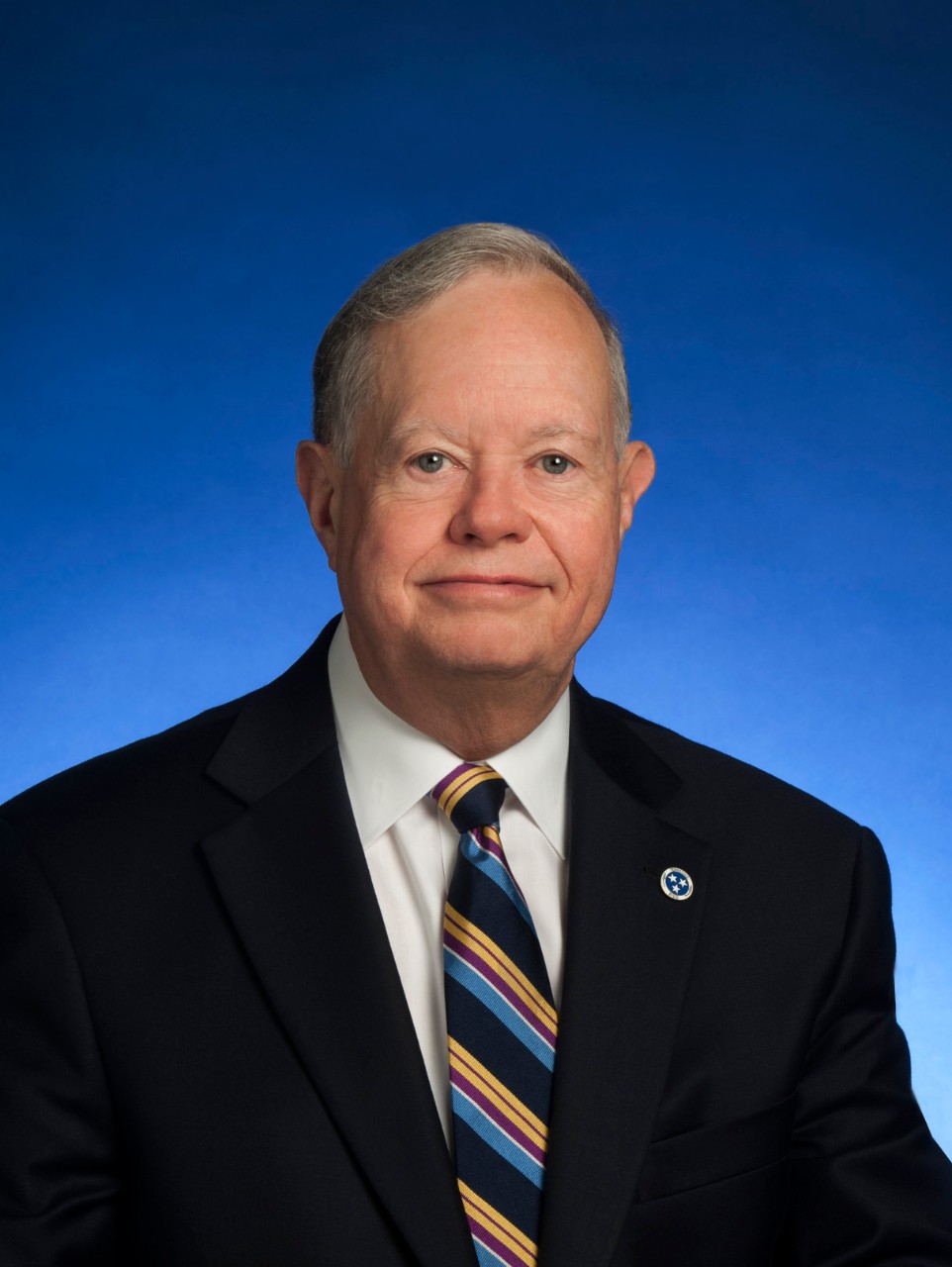 There is a photo of Dr. Cheetham in this article. He is wearing a suit and tie and has a state pin on his lapel.