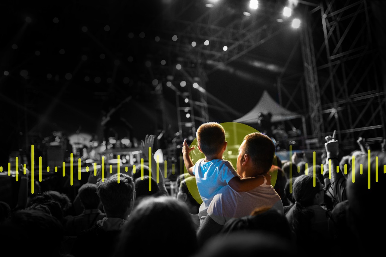Concert seen from the crowds with a young boy and his father watching the performance Concert seen from the crowds with a young boy and his father watching the performance