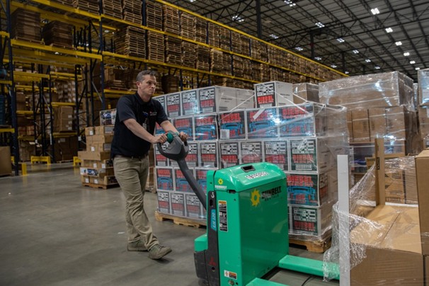 Tennessee Emergency Management Agency, Tripp Voss helps move proper protective equipment at Journey's Distributition during the initial fight against the spread of COVID-19 Man moving palettes of supplies in warehouse
