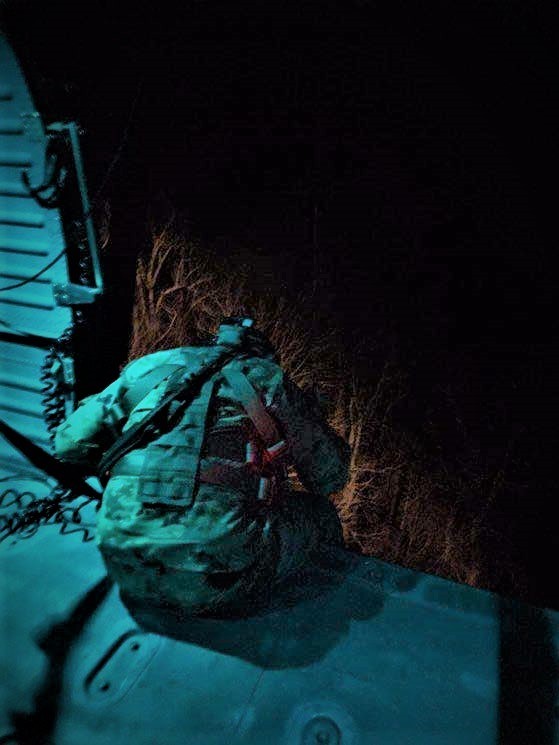 Tennessee Army National Guard Blackhawk helicopter crew chief, Sgt. Gabriel Weston, locates a hiker in distress and prepares the aircraft hoist to begin rescuing the hiker in the Great Smoky Mountain National Park, near the Silers Bald Shelter, along the Appalachian Trail, in the early morning of April 5. (Submitted photo)