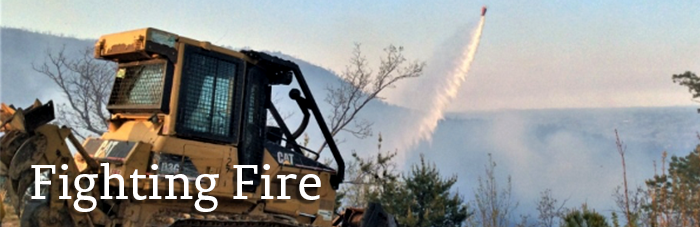Fighting Fire helicopter assisting dozer with wildfire